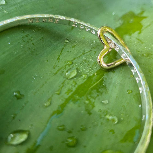 Gold heart charm on a sterling bangle