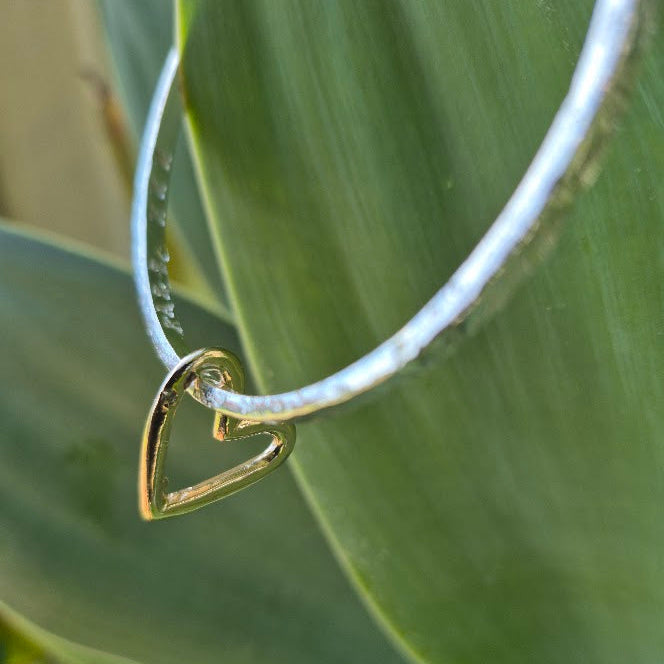 Gold heart charm on a sterling bangle